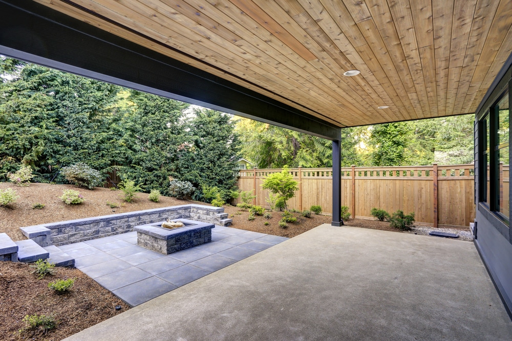 Is a Covered Deck or Porch Right for You? 1 New modern home features a backyard with covered patio accented with a wood plank ceiling and a rectangular fire pit, made of concrete and slate tiles. Northwest, USA