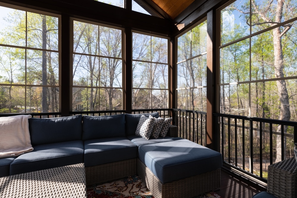Contemporary screened porch in springtime, full of blooms trees in the background. New home addition concept.